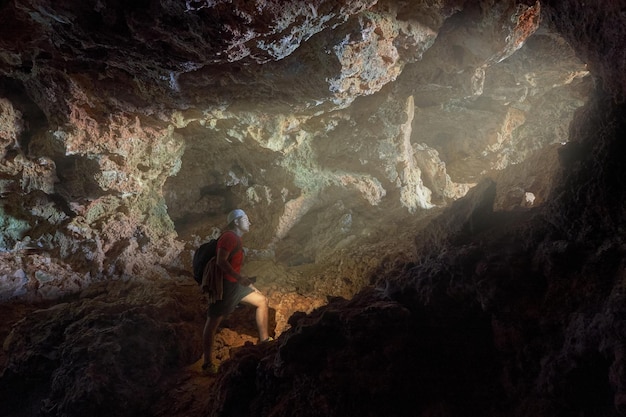 Photo adventurous hiker exploring the rocky cave in the mountain