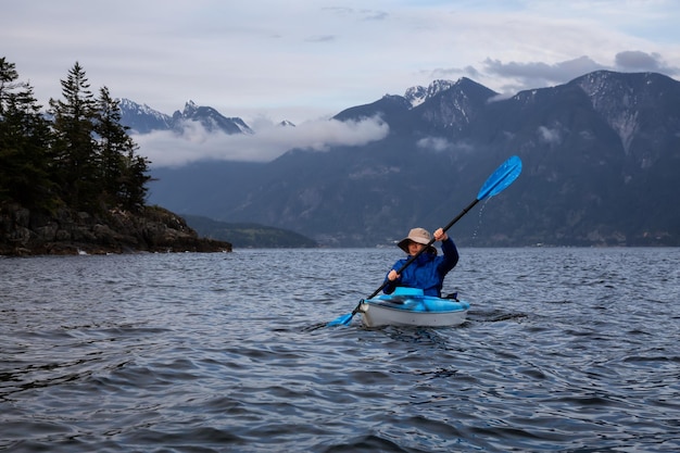 Adventurous man on a kayak is paddling in Howe Sound