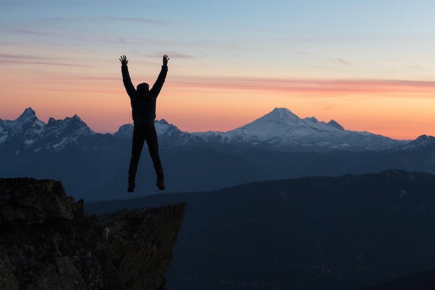 Adventurous man on top of the mountain