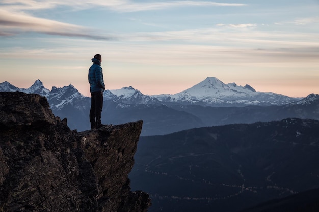 Adventurous man on top of the mountain