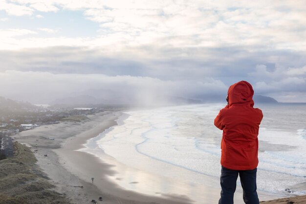 Adventurous man with a camera is standing taking pictures of the beach