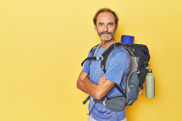 Adventurous man with mountain backpack in studio