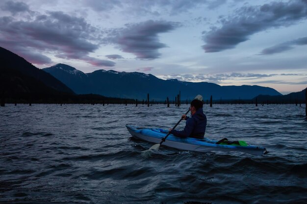 Adventurous people on a canoe are enjoying the Canadian Mountain Landscape