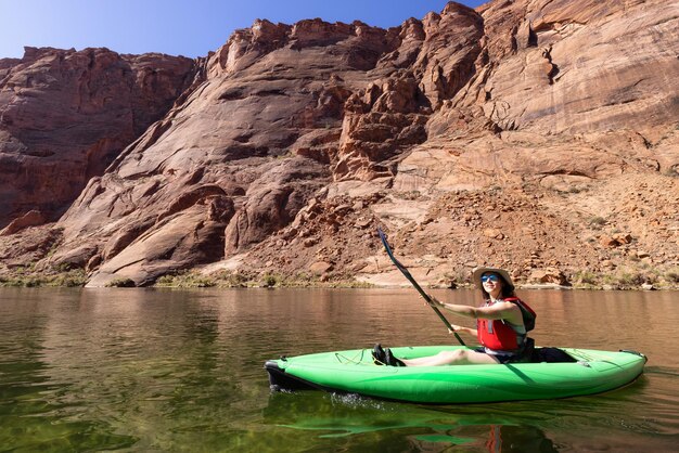 Adventurous woman on a kayak paddling in colorado river glen canyon arizona