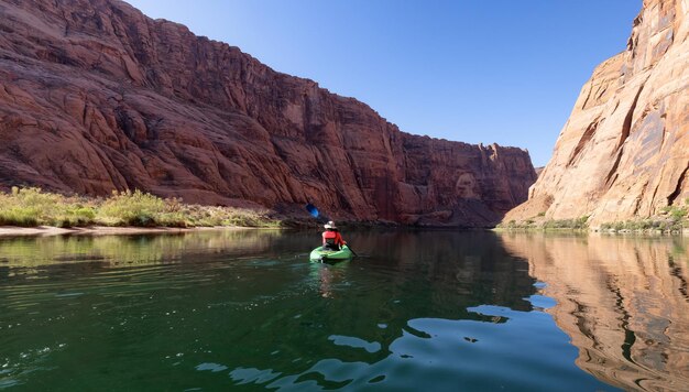 Adventurous woman on a kayak paddling in colorado river glen canyon arizona