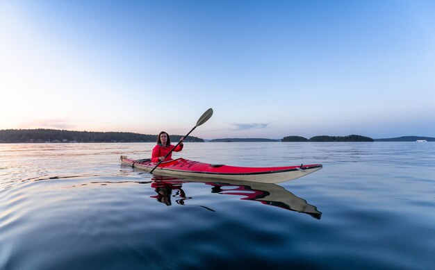 Adventurous woman on sea kayak paddling in the pacific ocean