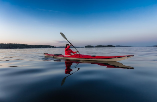 Adventurous Woman on Sea Kayak paddling in the Pacific Ocean