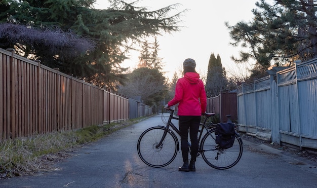 モデリーシティ郊外の路地に自転車で立っている冒険的な女性