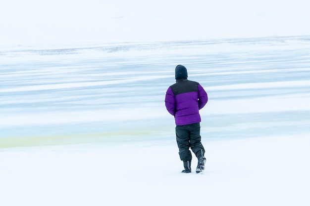 An adventurous young man walking on a frozen lake in winter in Iceland