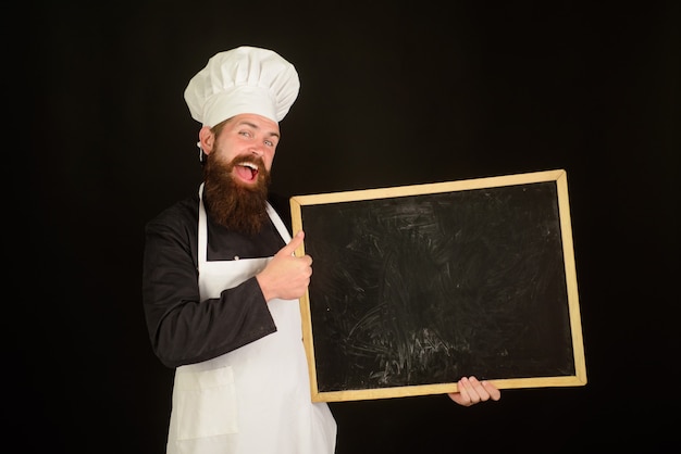 Advertentie happy chef hold blackboard man cook show leeg menu schoolbord met kopieerruimte glimlachend