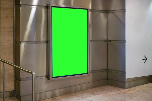 Advertising board display green mockup on steel wall tiles at underground passage