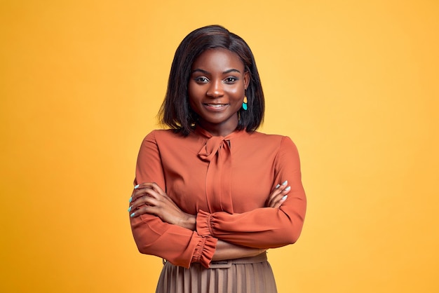 Photo advertising concept confident and smiling young african woman crossed hands looking at camera