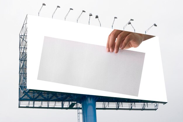 Photo advertising hand holding white empty paper on big billboard