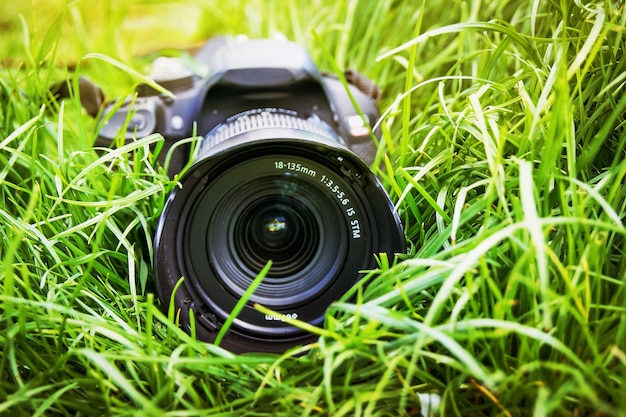 Photo advertising of professional photographic equipment. camera lies in grass