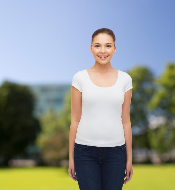写真 広告、夏休み、人々のコンセプト-公園の背景に空白の白いtシャツで若い女性を笑顔