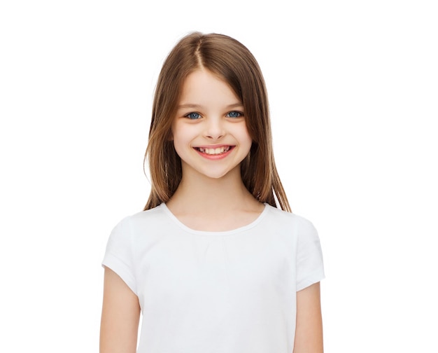 advertising and t-shirt design concept - smiling little girl in white blank t-shirt over white background