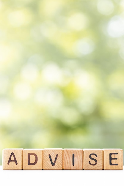 Advice word is written on wooden cubes on a green summer background Closeup of wooden elements