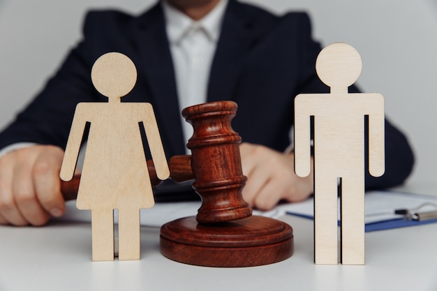 Foto advocaat of adviseur houdt hamer achter cijfers van jong gezin echtscheiding of scheiding concept