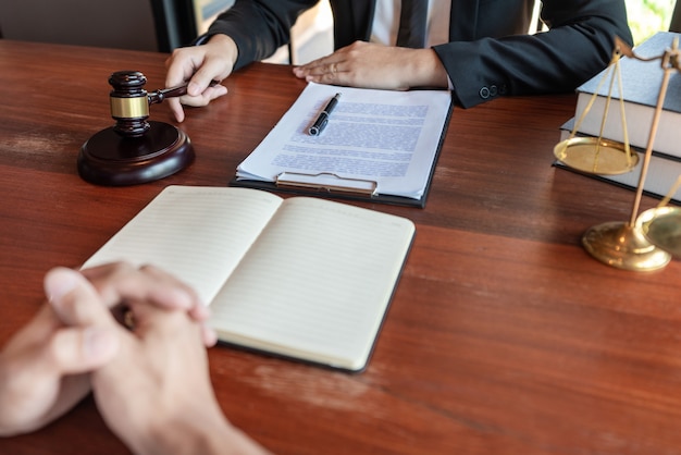Advocaat samen met cliënt bespreken over wettelijke wetgeving in rechtszaal