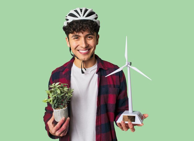 Advocating for clean energy young man holding a plant and a small windmill