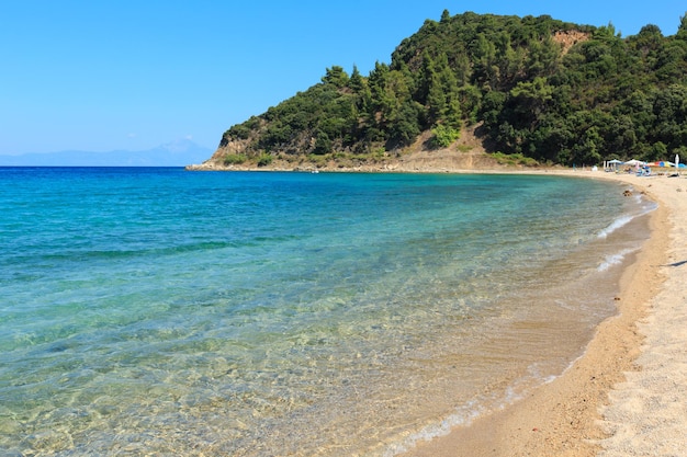 Aegean sea coast landscape view from sandy beach Chalkidiki Greece Peoples unrecognizable