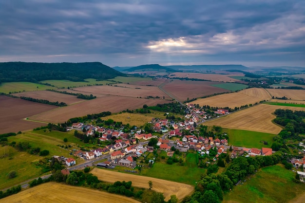 Aer ial view of a German village surrounded by meadows farmland and forest in Germany