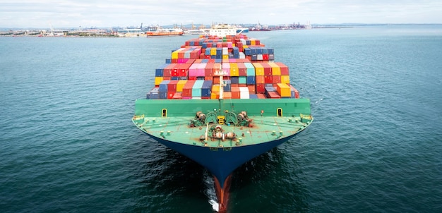 Aerial of cargo ship carrying container and running for export goods from cargo yard port to other ocean concept freight shipping ship