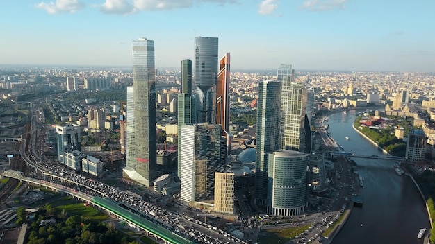 Aerial cityscape of Moscow, Russia. Camera flying over the road with heavy traffic and moving towards business centre with skyscrapers