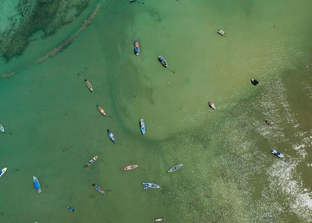 Aerial drone bird's eye view photo Top down of tropical sea with long tail fishing boats Travel boats at phuket thailand Amazing top view drone sea.