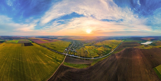 Aerial drone panoramic view of nature in Moldova at sunset. Village, lake, wide fields