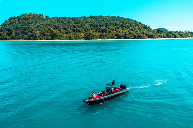 Photo aerial drone photo of inflatable power boat cruising in high speed in tropical emerald clear water sea