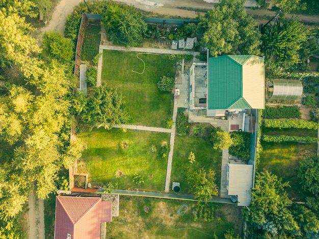 Aerial drone shot of summer countryside cottage with garden f