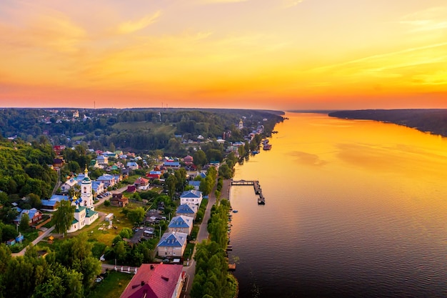 Aerial drone view of ancient russian town Ples on the Volga river with colorful sunset.