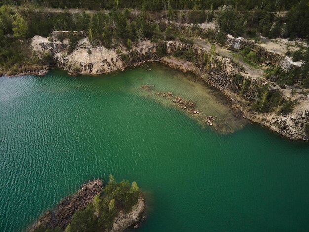 Aerial drone view Basalt columns Amazing industrial landscape on Emerald lake in a flooded quarry opencast mine Open pit mine with lake travel Ukraine