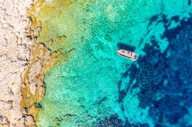 ターコイズブルーの水でボートの空中ドローンビューイオニア海ケファロニア島ギリシャ