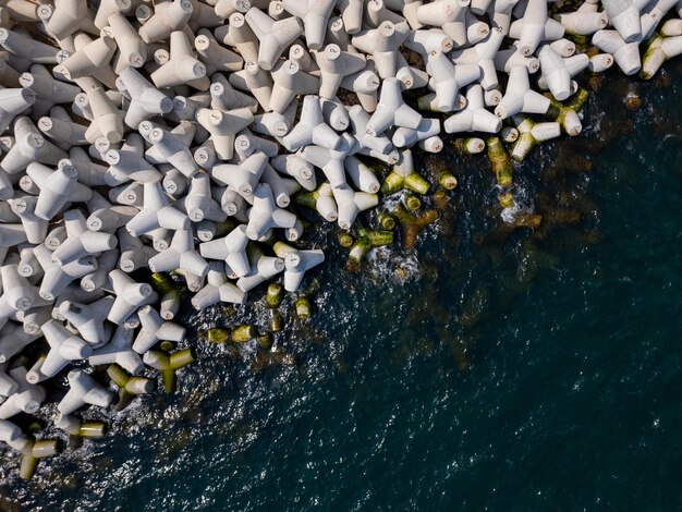 Photo aerial drone view of a breakwater breakwater in the sea a collection of concrete tetrapod breakers