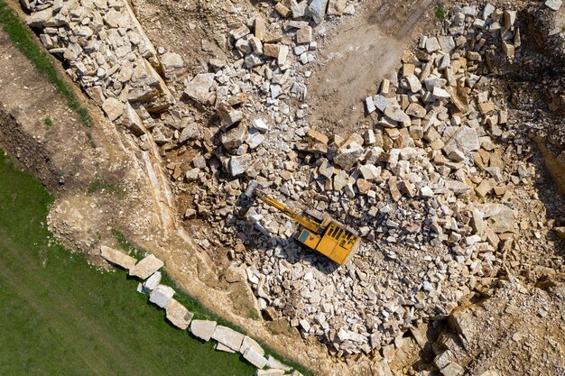 石灰岩採石場で働く掘削機のドローンからの空中写真
