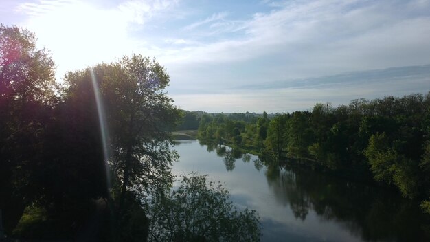 Aerial drone view flight over mirror smooth surface of river and trees