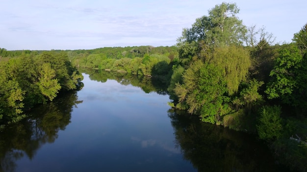 Aerial drone view flight over mirror smooth surface of river and trees