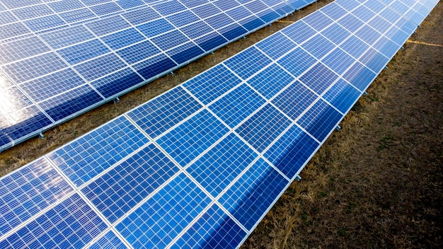 Aerial drone view flight over solar panels on sunny day closeup photovoltaic