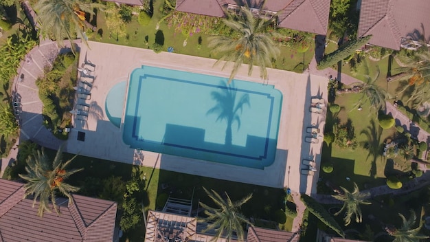 Aerial drone view of the hotel territory Top view Swimming pool palm trees sun loungers Holidays at the resort