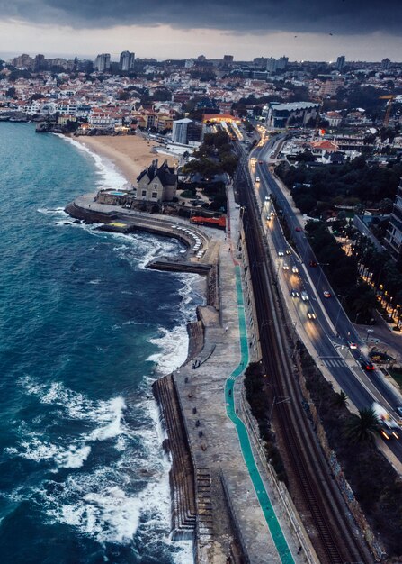 Aerial drone view of Marginal Avenue and coastline with looking west towards Cascais on a cloudy autumn day