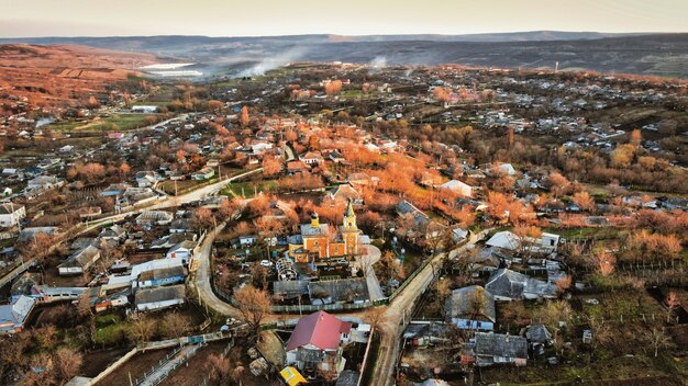 写真 日没時のモルドバの村の空中ドローンビュー古い住宅の建物の教会