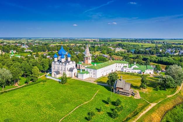 写真 ロシアのカメンカ川にあるスーズダリスキーレムリンとキリスト降誕大聖堂の空中ドローンビュー。夏の晴れた日。