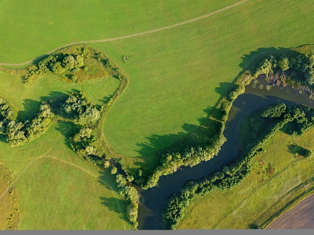 Фото Вид с воздуха с дрона на реку среди полей средняя полоса россии