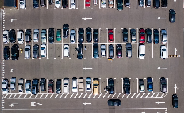 Aerial drone view of parking lot with many cars from above, city transportation and urban concept