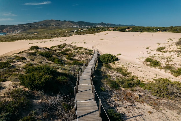 Aerial drone view of pedestrian path to Guincho Beach in Cascais Portugal next to sand dunes