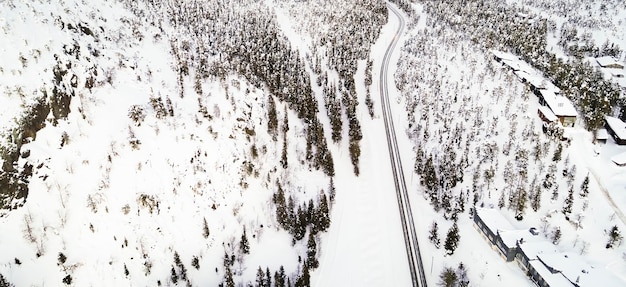 Aerial drone view of road in idyllic winter landscape Street running through the nature from a birds eye view