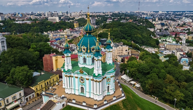 Вид с воздуха с беспилотника на Андреевскую церковь и Андреевскую улицу сверху городского пейзажа Подола