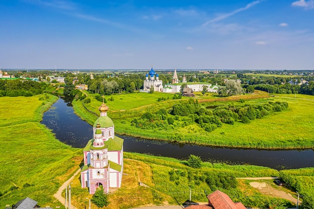 Aerial drone view of Suzdal Kremlin and cathedral of Nativity with the Church of Elijah the Prophet at the Kamenka river, Russia. Summer sunny day.